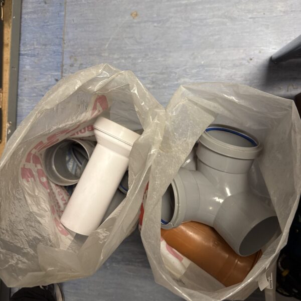 Mixed lot of used PVC drainage stack plumbing fittings.