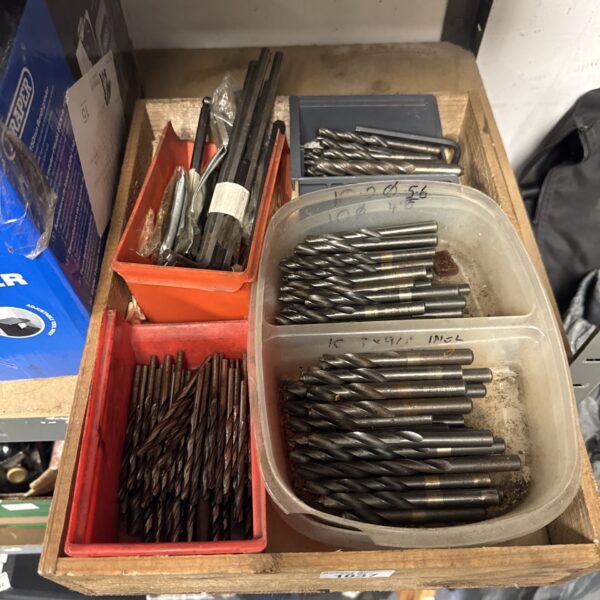 Selection of drill bits and Allen keys in a plastic container.