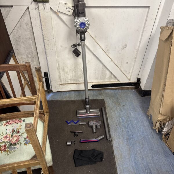 Dyson V6 cordless vacuum cleaner with charger and attachments.