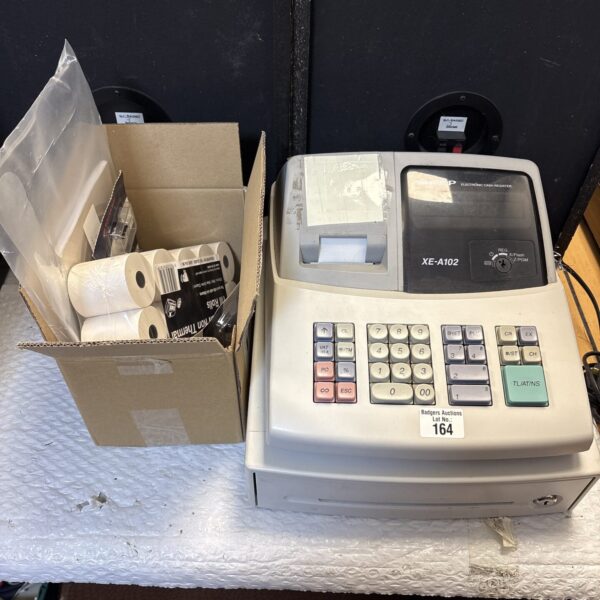 Vintage electronic cash register XE-A102 with rolls.