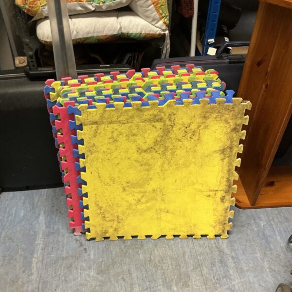 Interlocking foam floor mats in red, blue, and yellow.