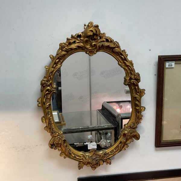 Ornate gilt framed French boudoir mirror with intricate detailing.