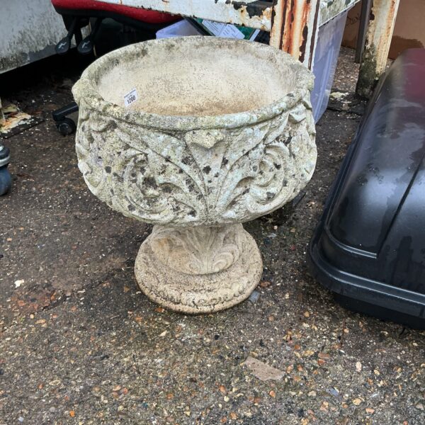 Vintage stone garden planter with embossed floral design.