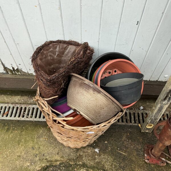 Assorted garden pots in a woven basket for planting.