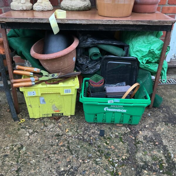 Mixed lot of terracotta pots and gardening tools for outdoor use.
