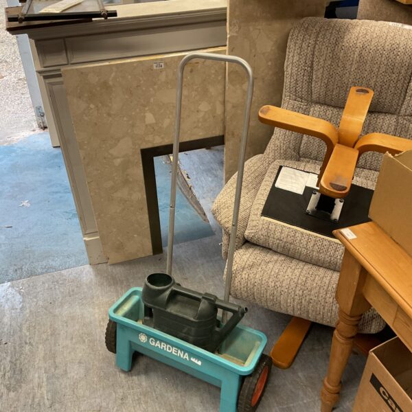 Used Gardena seed spreader and watering can for garden maintenance.
