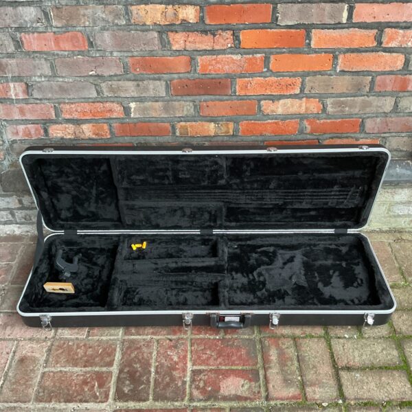 Black Gator hard guitar case with visible wear and tear.