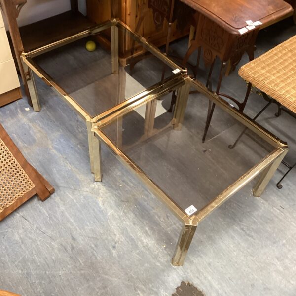 Two glass top coffee tables with metal frames.