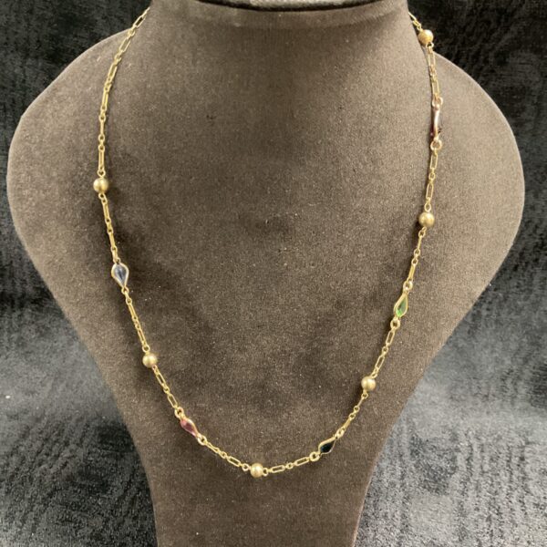 Vintage gold filled necklace with colourful stones on display.