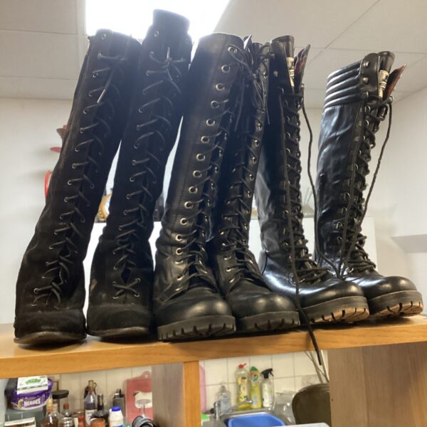 Close-up of three pairs of black goth boots, including Rocket Dog.