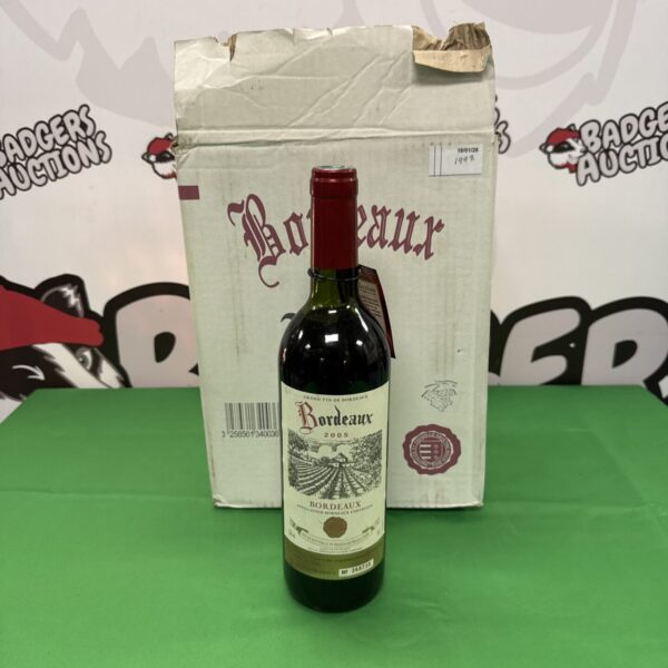 Three bottles of Grand Vin de Bordeaux 2005 vintage in packaging.
