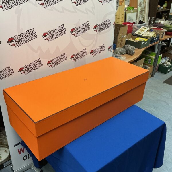 Orange Hermes storage box displayed with backdrop.