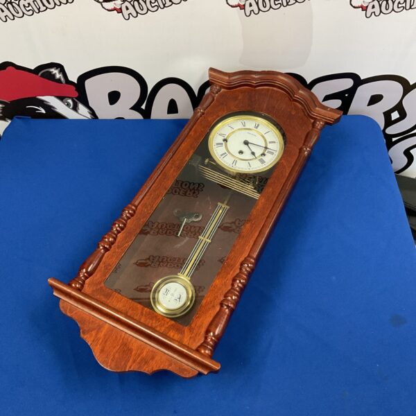 Vintage Hermle wall clock with pendulum and key.
