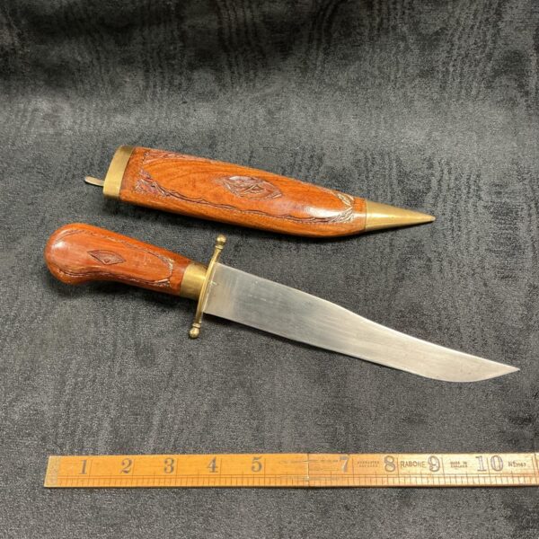 Antique Indian dagger with carved wooden handle and brass fittings.