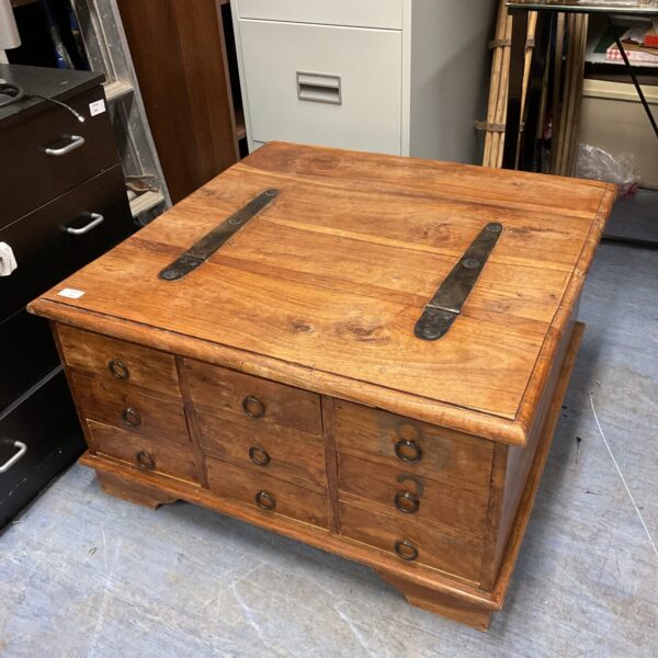 Front view of a rustic Indian oak coffee table with drawers.
