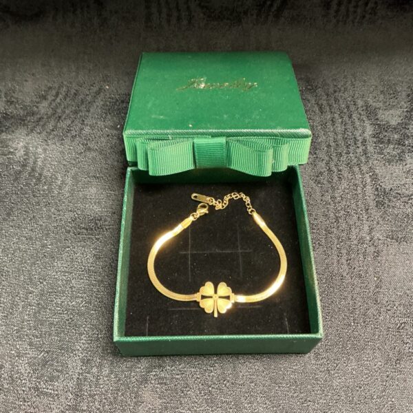 Gold plated Irish clover bracelet on a velvet display box.