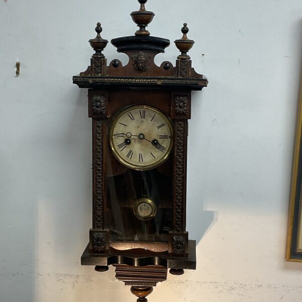 Vintage Junghans wall clock with pendulum movement and carved details.