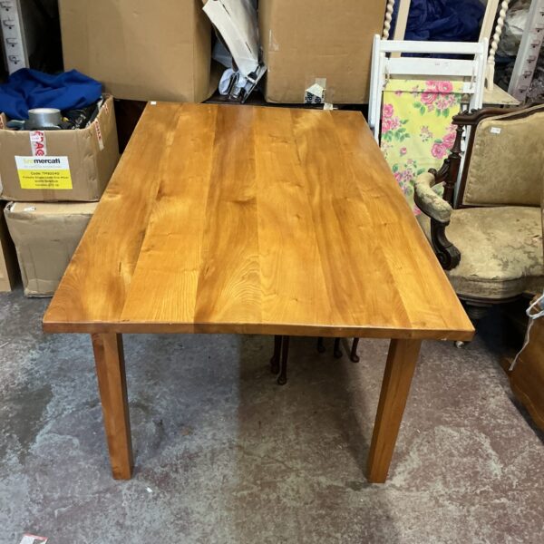 Large farmhouse dining room table, solid wood construction.