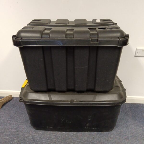 Two large plastic storage boxes, one with a cracked lid, for household storage.