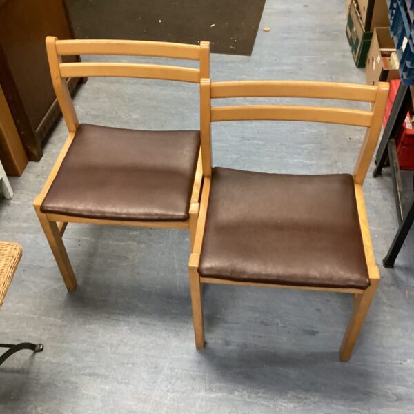 Pair of vintage leather top dining chairs with wooden frames.