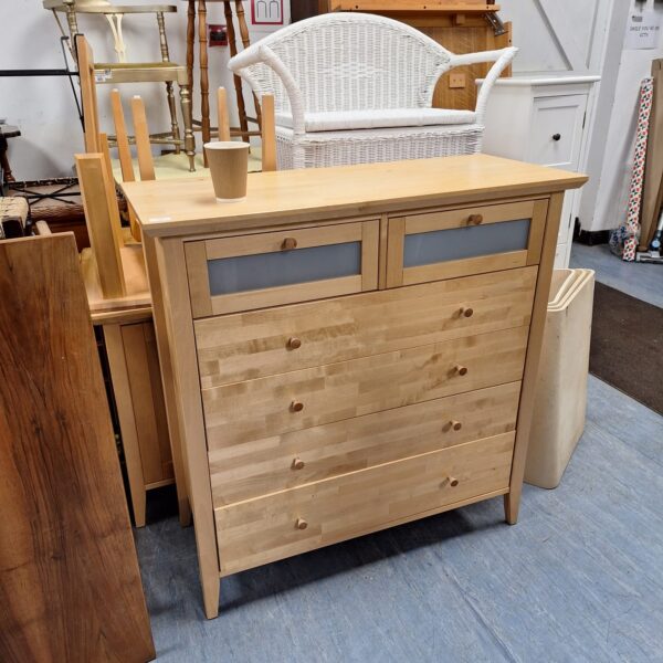Front view of a light oak chest of drawers with two over four drawers.