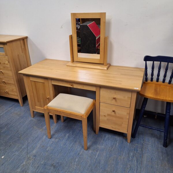 Vintage light oak dressing table with mirror and stool in a bedroom setting.