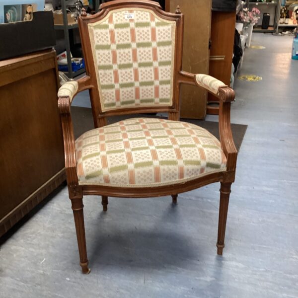 Antique Louis XVI armchair with patterned upholstery and carved details.