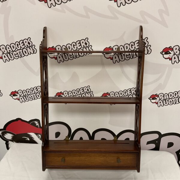 Antique mahogany wall shelf with drawer for display and storage.
