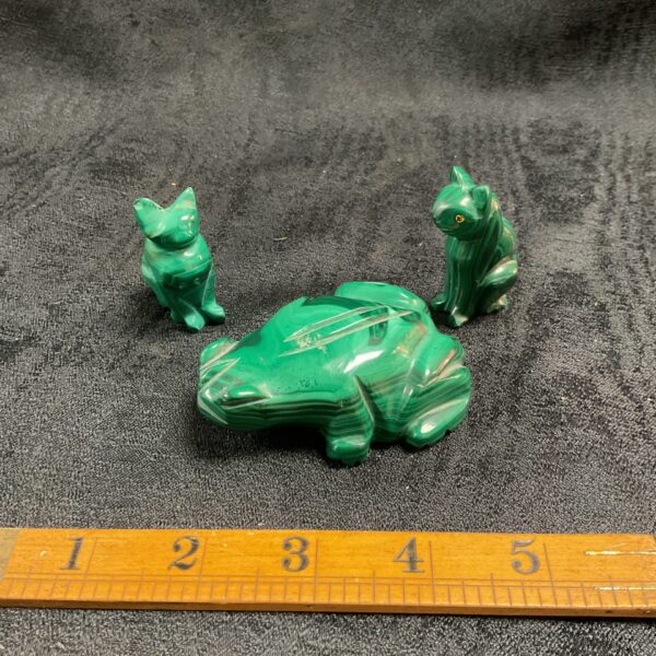 Vibrant green malachite carvings of a frog and two cats.