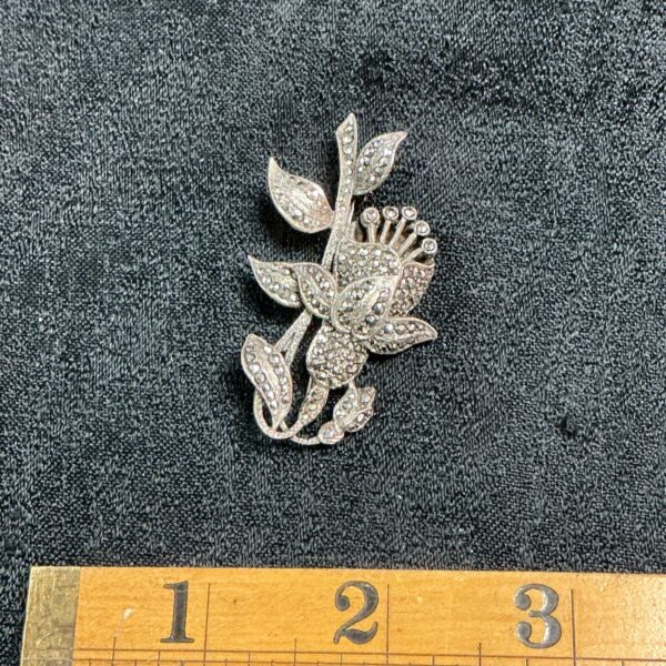 Vintage silver-tone marcasite flower brooch with sparkling stones.