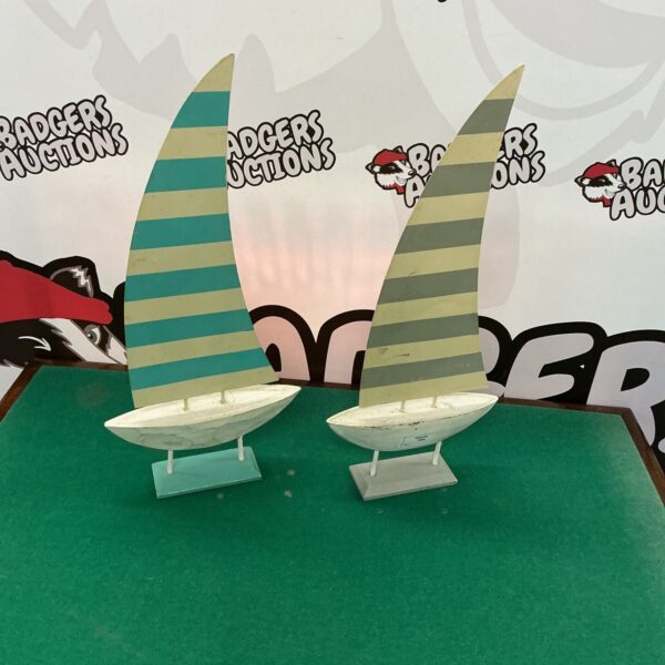 Vintage metal sailing boat ornaments on a display background.
