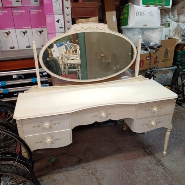 White mid-century dressing table with oval mirror and drawers.