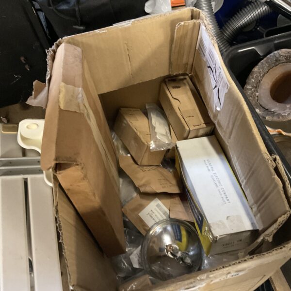 Vintage military lamp components in a cardboard box.