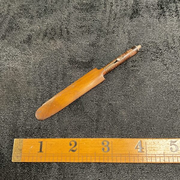 Vintage miniature cricket bat pencil displayed with ruler.