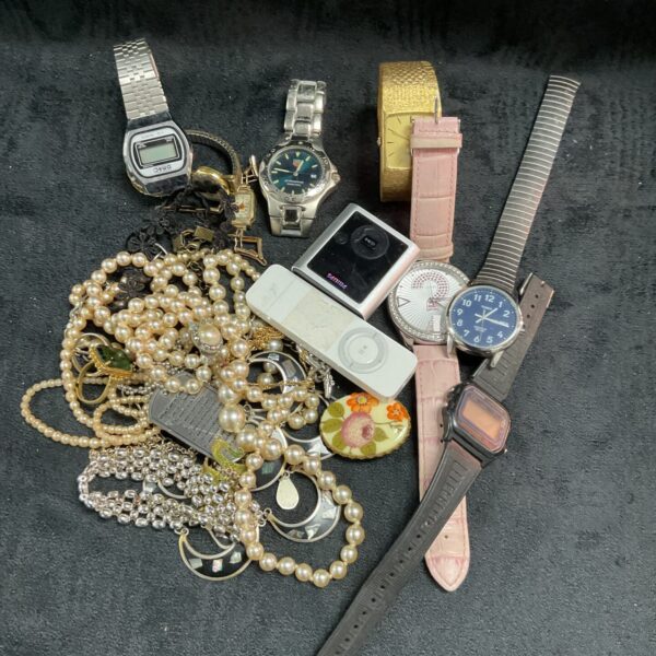 Mixed lot of vintage watches and jewellery on display.