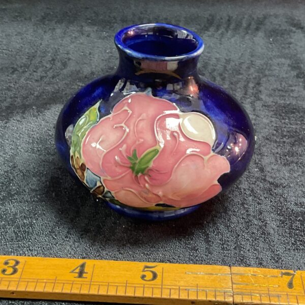 Vintage Moorcroft magnolia vase with blue ground and floral design.