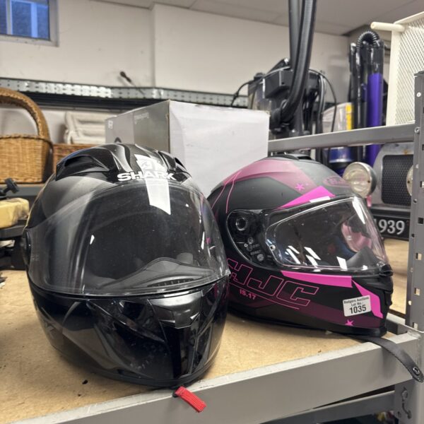 Pair of black and red motorcycle helmets, Shark and HJC brands.