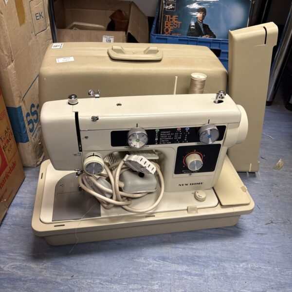Vintage New Home sewing machine in used condition.