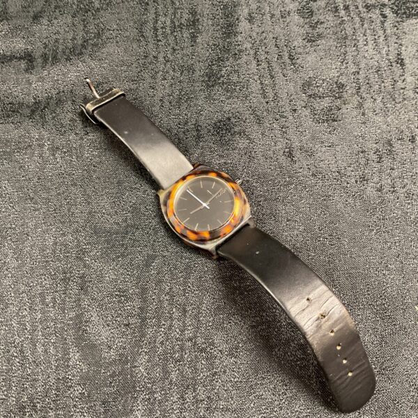 Front view of a vintage Nixon tortoise shell wristwatch.