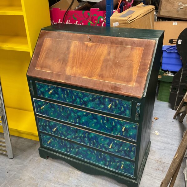 Front view of a peacock bureau with colourful drawers.