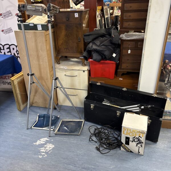 Vintage photography equipment lot with Lowel Tota lights and tripods.