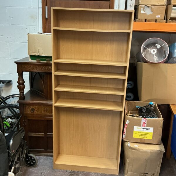 Tall pine bookcase with multiple shelves for storage.