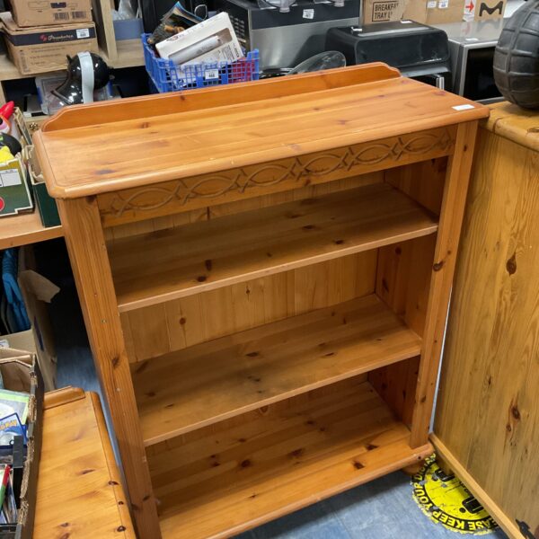 Small pine bookcase with three tiers for books and storage.