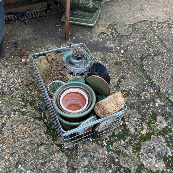 Mixed lot of terracotta and ceramic plant pots in a tray.