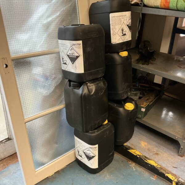 Lot of six empty UN rated plastic drums for storage.