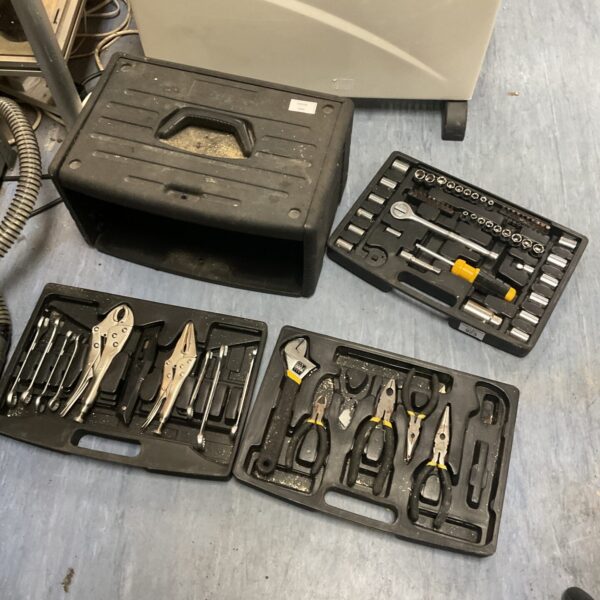 Used plastic toolbox with assorted hand tools inside.
