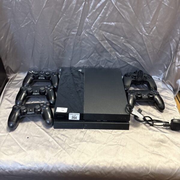 Sony PlayStation 4 console with five controllers for gaming.
