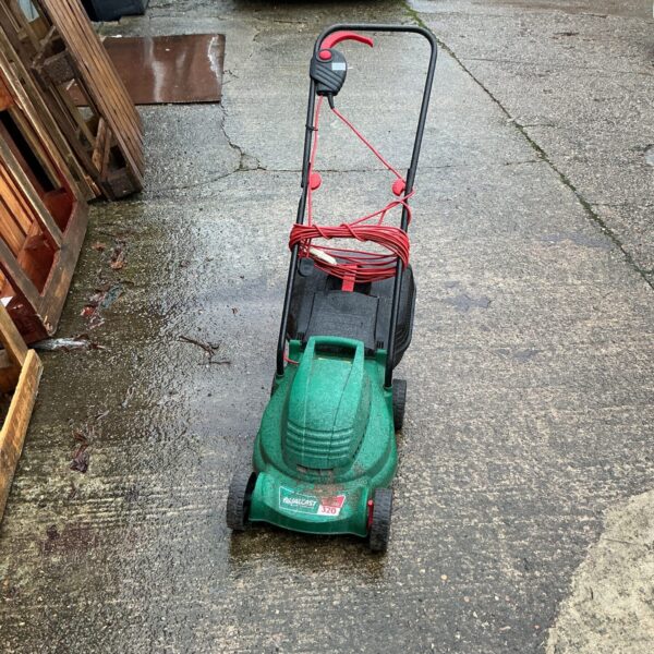 Green Qualcast electric lawnmower in a garden setting.