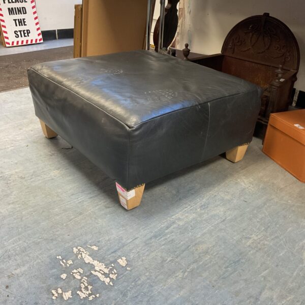 Black leather Ralph Lauren footstool with wooden legs.