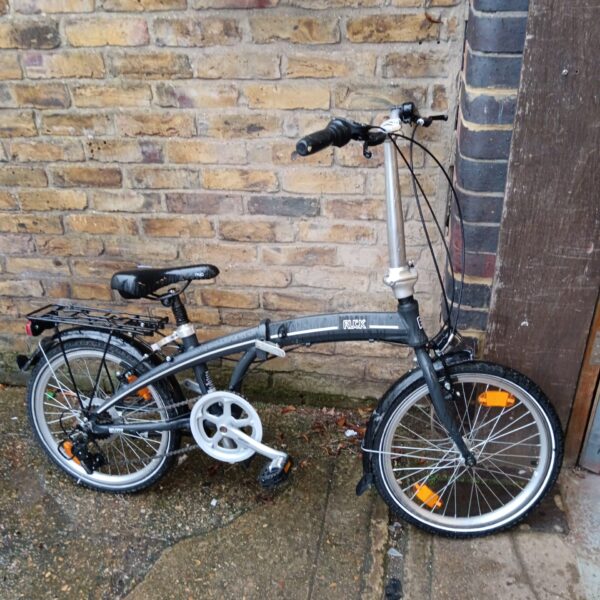 Side view of a used Ruck folding bicycle with a rear rack.
